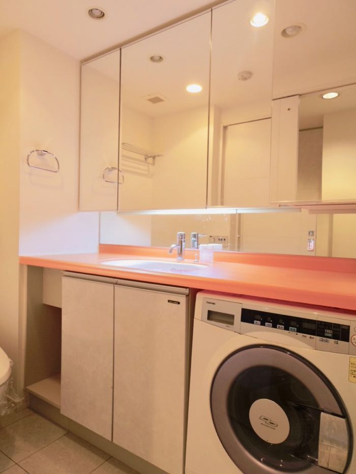 ドラム式洗濯機完備のパウダールームはオレンジでカラーリング